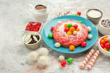 front view delicious pink cake with colorful candies on white background dessert goodie rainbow color cake candy