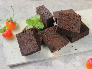 Slices of Brownies Kukus or steamed brownies or rich chocolate cake on white tray