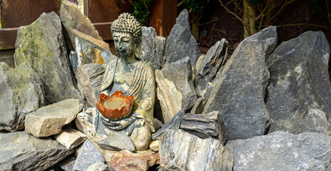 panorama Buddha statue sits in a rock garden
