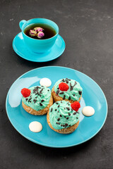 front view little creamy cakes delicious sweets with cup of tea on the dark background tea cream cake biscuit dessert color