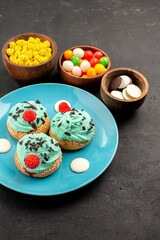 front view little creamy cakes with candies on dark background dessert cake biscuit color candy cookie