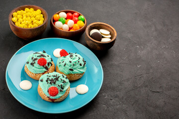 front view little creamy cakes with candies on dark background dessert cake biscuit color candy cream