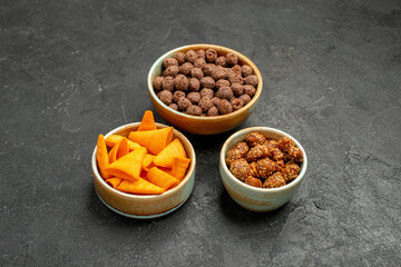Obraz na płótnie Canvas front view orange cips with sweet nuts and flakes on grey background snack meal breakfast nut