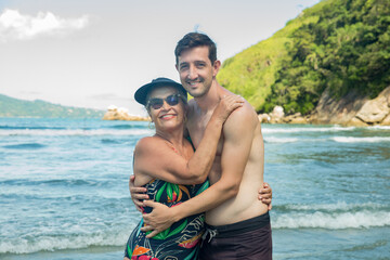 Fototapeta na wymiar Mãe e filho abraçados na praia