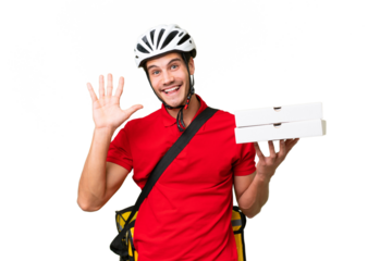 Pizza delivery man with work uniform picking up pizza boxes over isolated background saluting with hand with happy expression