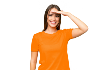 Young pretty caucasian woman over isolated background saluting with hand with happy expression