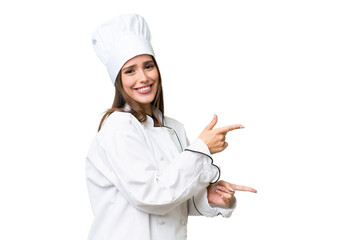 Young chef caucasian woman over isolated background pointing finger to the side and presenting a product