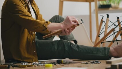 Furniture, A young parent independently Assembles quickly prefabricated furniture with his own hands In a private house, Assembles home furniture according to instructions in cramped room working tool