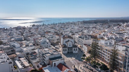 Obraz premium Aerial view of Portuguese fishing tourist town of Olhao overlooking Ria Formosa Marine Park. church Matriz de Nossa Senhora do Rosario