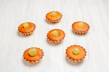 front view yummy little cakes perfect sweets for tea lined on a white desk cake pie sweet dessert tea cookies