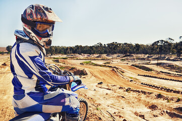 Portrait, motorcycle and man on a dirt track for action, competition or a sports race outdoor....