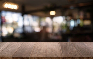 Empty dark wooden table in front of abstract blurred bokeh background of restaurant . can be used for display or montage your products.Mock up for space.