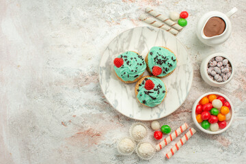 top view colorful candies with creamy cakes on white background color rainbow biscuit tea cake