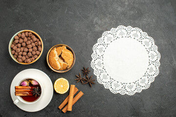 Obraz na płótnie Canvas top view cup of tea with cinnamon on dark-grey background tea drink ceremony sweet