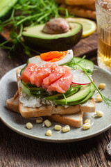 toasts with cream cheese, salmon, egg, avocado, cucumber  in a plate