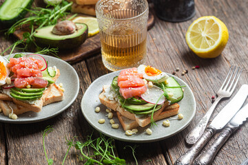 toasts with cream cheese, salmon, egg, avocado, cucumber  in a plate