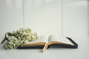 Open bible with flowers on a white background