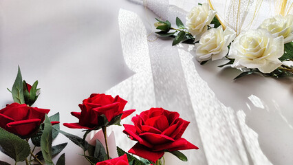 Background and texture with beautiful white and red roses with light and shadow from sun. Abstract cart with frame framed with roses, copy space and place for text. Concept of beauty, gifts, holiday