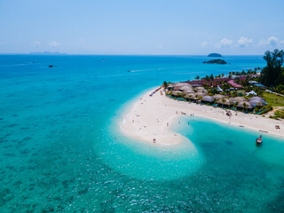 Obraz premium men and women walking on a sandbar in the ocean of Koh lipe Southern Thailand during vacation