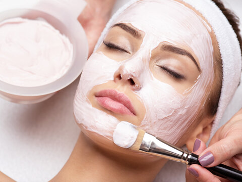 woman receiving  facial mask in spa beauty salon