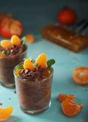 Chocolate mousse dessert with tangerines in glasses
