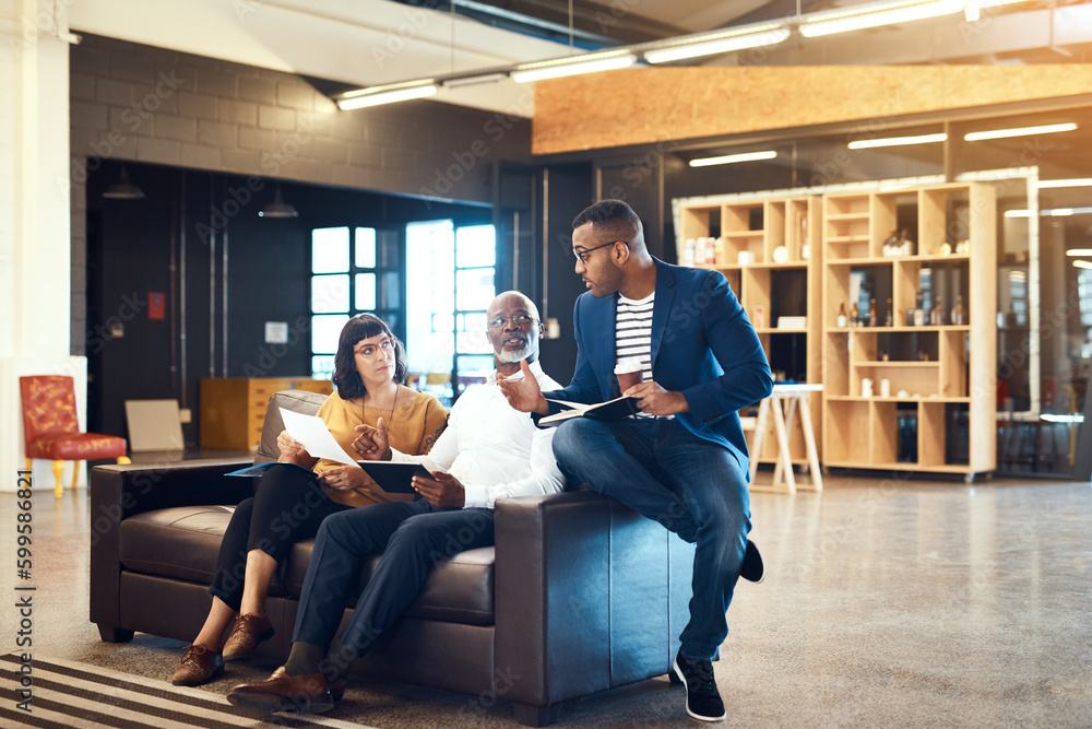 Poster Discussing some finer details with the team. Full length shot of a group of designers having a discussion in an office.
