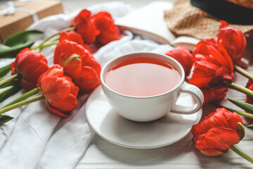 Beautiful spring composition, good morning concept. Cup of tea, peonies, open book