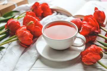 Beautiful spring composition, good morning concept. Cup of tea, peonies, open book