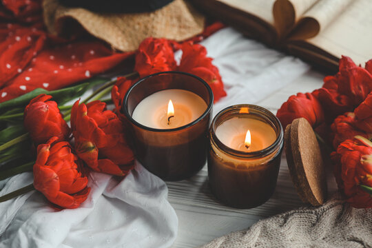 Two burning candles in home interior, book with heart, aesthetic photo