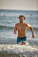 Fototapeta premium man running in the water on the beach