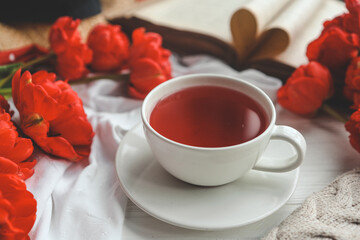 Beautiful spring composition, good morning concept. Cup of tea, peonies, open old book