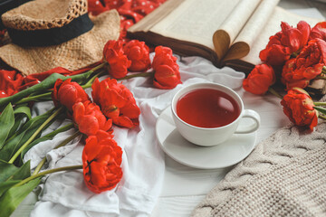 Beautiful spring composition, good morning concept. Cup of tea, peonies, open old book