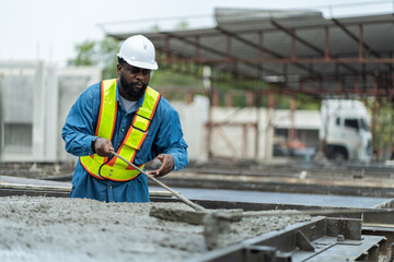 Male worker in a precast wall factory (Precast) is forming a wall with cement. and smooth the plaster in the prepared mold