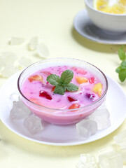 sop buah or fruit soup is indonesian fruit cocktail ice made from various diced fruits mixed with ice cubes, condensed milk and red syrup. popular food for breakfasting