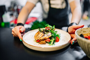 Chef cooking Caesar salad on restaurant kitchen