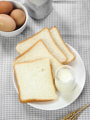 Sliced Toast Loaf White Bread (Shokupan or Roti Tawar) for Breakfast on Wooden Background, Served with Egg and Milk. Breakfast Concept Picture