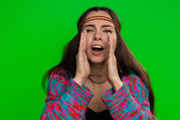 Young hippie woman shouting, screaming, yelling with hands near mouth. Puzzled clueless uncertain girl raising hands in helpless gesture, embarrassed confused isolated on green chroma key background