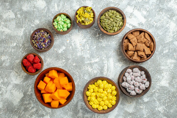 top view different candies with flowers on white background color candy sugar tea flower