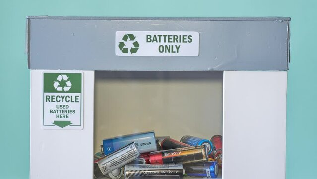 Used alkaline batteries in a special container. Toxic waste recycling. Stop motion animation