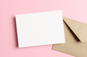 Obraz na płótnie Canvas Minimalistic invitation card mockup with envelope and copy space on pink background