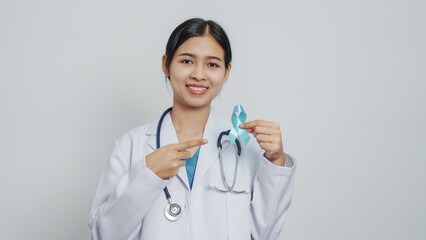 Doctor asian female specialist holding blue ribbon and stethoscope and Breast cancer awareness concept