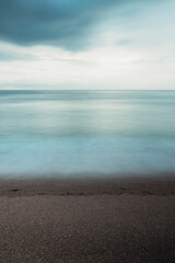 Long exposure of the blue sea on an empty coastline