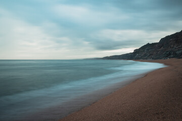 Long exposure of the blue sea on an empty coastline