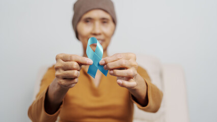 Mature woman suffering from cancer, asian people, 70s years old with head scarf, blue ribbon, elderly National Cancer Awareness Day concept.