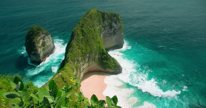 Green cape in tropical thickets on pristine island of Nusa Penida - Kelingking beach with turquoise ocean and golden sand in Indonesia.