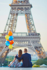 Couple with colorful balloons looking at the Eiffel tower