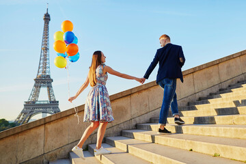 Romantic couple with colorful balloons near the Eiffel tower