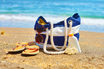 Beach bag, flip flops, and sunscreen bottle