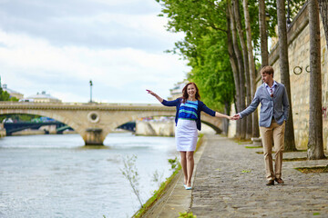 Fototapeta na wymiar Couple is walking by the Seine