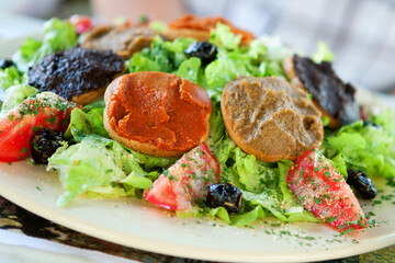 Delicious Provencal salad: fresh vegetables, olives, olive oil and toasts with different sorts of tapenade